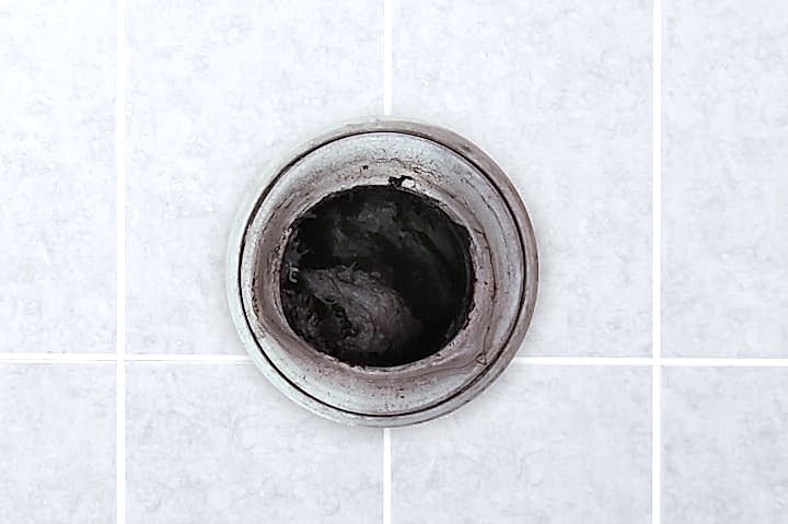A Servpro technician is unclogging a dirty kitchen drain. The image shows the technician using specialized tools to clear the blockage and restore proper drainage. The scene emphasizes the importance of professional plumbing services in maintaining a clean and functional kitchen sink