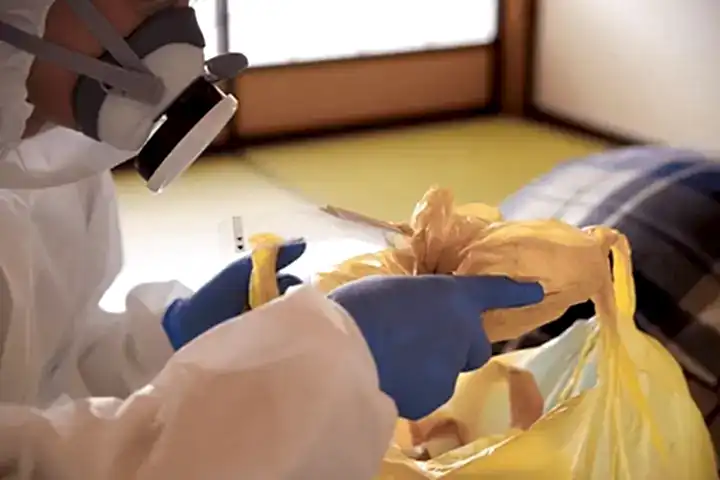 a person tying together a collection bag