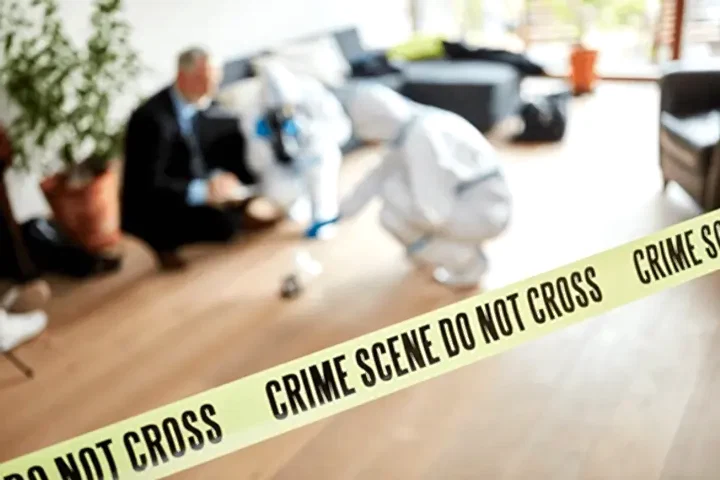 crime scene tape with people cleaning in the background